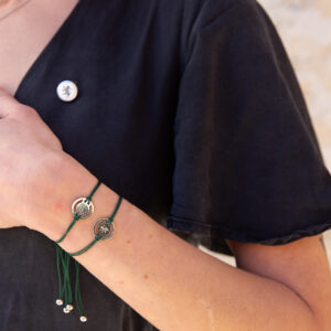 Foto em ambiente com pulseiras e Pin em prata da coleção Sporting CP Jewels da Leitão & Irmão